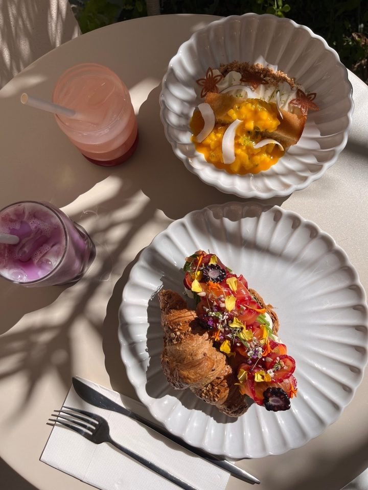 Croissant garni de saumon et de fleurs, bowl mangue coco, vus du dessus